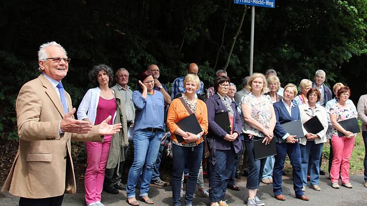 Mit der Benennung eines Weges im Pfarrschrot ehrte die Gemeinde Niederfüllbach am Samstag ihren verstorbenen Ehrenbürger Franz Möckl. "Franz Möckl hat das Chor- und Verbandsleben ganz gewaltig geprägt", sagte der Vorsitzende des Fränkischen Sängerbundes Peter Jacobi (vorn). Die Einweihung wurde untermalt von Liedern des Komponisten, vorgetragen vom Singverein Niederfüllbach (Leitung Carolin Heckel, links), den Möckl viele Jahre geleitet hatte.Foto: Bettina Knauth