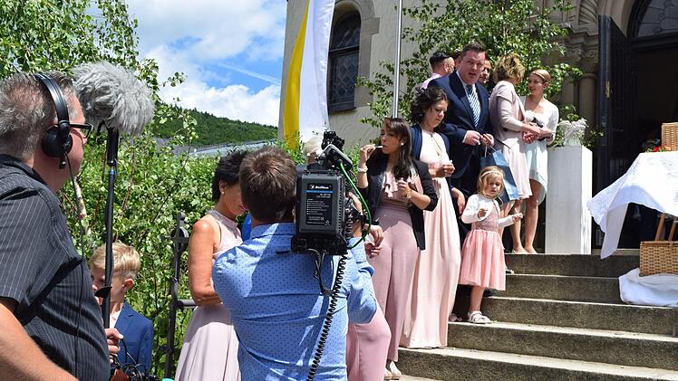 Die Aufnahme läuft schon, nur das Brautpaar fehlt noch: Die Gäste und das Kamerateam positionieren sich, bevor das frisch vermählte Paar vor die Kirche tritt. Foto: Daniela Pondelicek