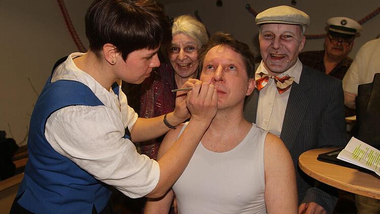 Auch die Maske muss natürlich passen. Susanne Heckelmann mit Bernd Stretz als Ebenbild von Pfarrer Dr. Rusin, dahinter das Ehepaar Schmitz.