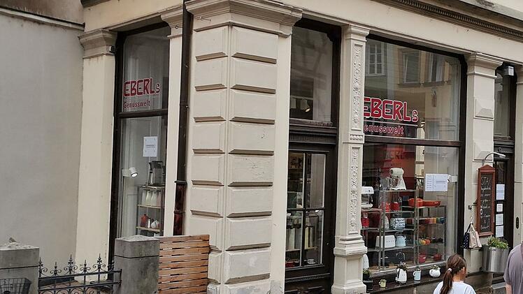 Geschäft in der Bamberger Altstadt, „Eberl's Genusswelt“, wird geschlossen. Schaufenster zeigt Küchengeräte und Dekoartikel, Menschen vorbeigehend. Historische Fassade.