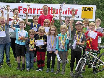 So sehen Sieger aus: Erfreut präsentieren die Sonnefelder Fahrradchampignons ihre errungenen Pokale und Plaketten. In der Bildmitte ADAC-Fahrradreferent Dieter Tenschert. Foto: Klaus Oelzner