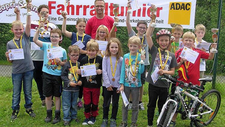 So sehen Sieger aus: Erfreut präsentieren die Sonnefelder Fahrradchampignons ihre errungenen Pokale und Plaketten. In der Bildmitte ADAC-Fahrradreferent Dieter Tenschert. Foto: Klaus Oelzner
