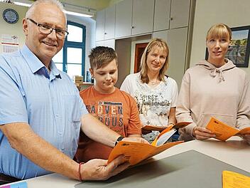 Bl&auml;tterten durch das Ferienprogramm (von links): B&uuml;rgermeister Hans Tischh&ouml;fer, Felix, Alien Berisha und Andrea Estorf. Foto: Bruno Prei&szlig;inger