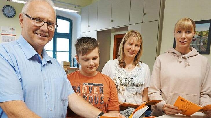 Bl&auml;tterten durch das Ferienprogramm (von links): B&uuml;rgermeister Hans Tischh&ouml;fer, Felix, Alien Berisha und Andrea Estorf. Foto: Bruno Prei&szlig;inger