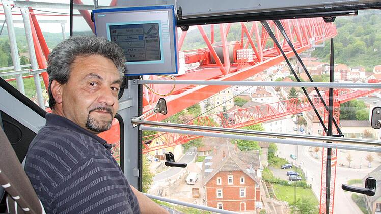 In 36 Metern Höhe hat Kranführer Sandu Vergil die beste Aussicht über die Baustelle für das neue Seniorenzentrum Haus Waldenfels. Seine Anweisung erhält der Rumäne per Funk von einem Dolmetscher unten. Foto: Ruppert