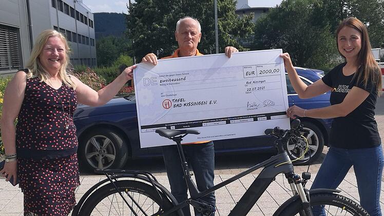 Wolfgang Speyer (Mitte) nimmt als Vertreter und  Vorsitzender des Vereins Tafel Bad Kissingen e. V. die Spende von Dr. Elisabeth Müller (links) und Christina Diem-Puello (rechts) entgegen.