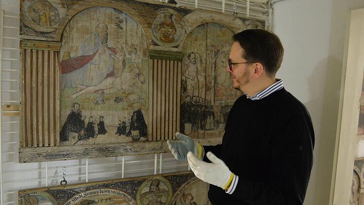 Alexander Süß an einer der Emporetafeln der Nikolauskapelle. Die Tafeln stammen aus den Jahren 1591 bis 1594. Foto: Ronald Rinklef
