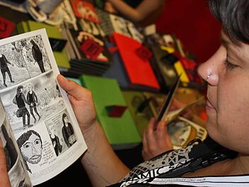 Die Comiczeichnerin Marlene Krause blättert in ihrem Buch "Choking on heroes".