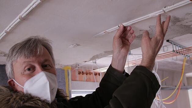 Architekt Ralf Alsheimer zeigt, wie ein aus Gips nachgefertigtes Ornament in die alte Stuckdecke eingepasst wird. Foto: Benedikt Borst