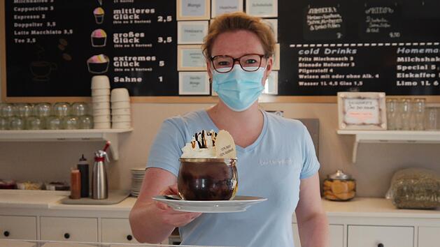 Anja Lang reicht in der Eisdiele der Eisheiligen in Hettenhausen bei Gersfeld eine Cookie-Bowl &uuml;ber den Tresen. Seit 2017 produzieren die Eisheiligen in der Rh&ouml;n Eis ohne Zusatzstoffe. Foto: Rebecca Vogt