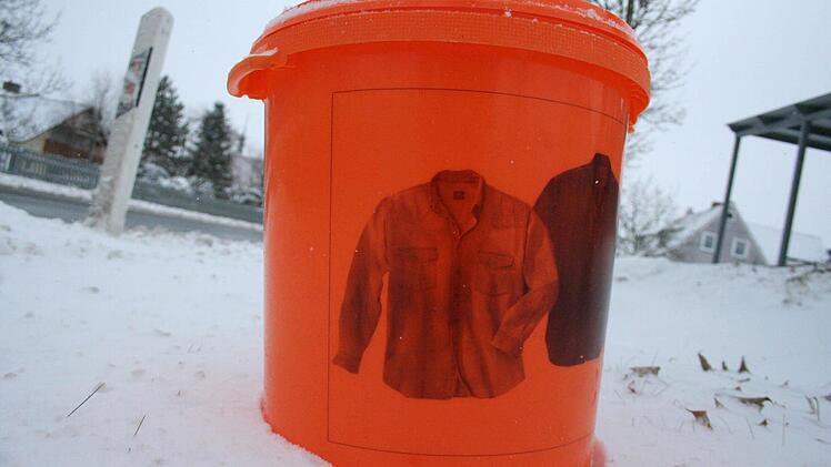 Ein Junge wirft seine abgetragenen Turnschuhe in einen der Sammeleimer.  Foto: Daniela Röllinger