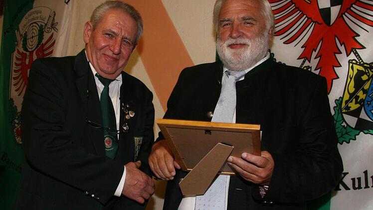 Der Vorsitzende Gerhard Neugebauer gratuliert Ehrenmitglied Reinhard Grampp.  Er ist seit 50 Jahren bei den Schützen.