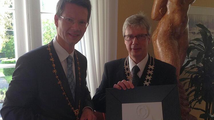 Sebastian Remelé überreicht Jorma Rasinmäki das Gastgeschenk: Ein Relief, das die drei Säulen Schweinfurts darstellt - reichsstädtische Geschichte, Kultur und Hightech/Wissenschaft.