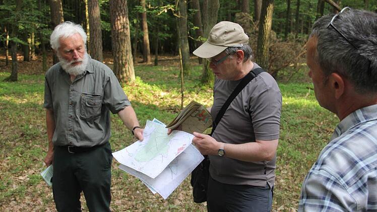 Franz Eder, Leonhard Bühl und Wolfgang Gnannt (von links); Leonhard Bühl zeigt eine Topografische Karte des Gemeindewalds Untermerzbach, anhand derer er sich durch den Wald vorarbeitet.Foto: Katharina Becht