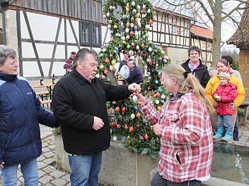 Dem Schlosser Leo Knübben (zweiter von links) war es vorbehalten, das letzte Ei an Giesela Baumann (vorne rechts) zu reichen, die dieses an der Osterkrone anbrachte. Links Nelli Knüppen, Ehefrau des "Osterkronenerschaffers."  Foto: Helmut Will
