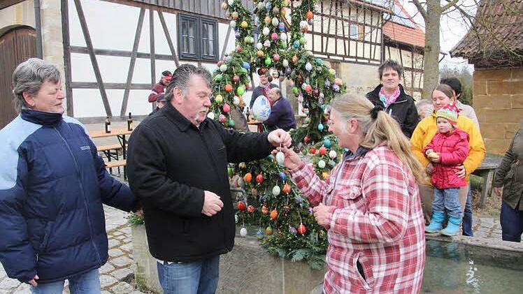 Dem Schlosser Leo Knübben (zweiter von links) war es vorbehalten, das letzte Ei an Giesela Baumann (vorne rechts) zu reichen, die dieses an der Osterkrone anbrachte. Links Nelli Knüppen, Ehefrau des "Osterkronenerschaffers."  Foto: Helmut Will