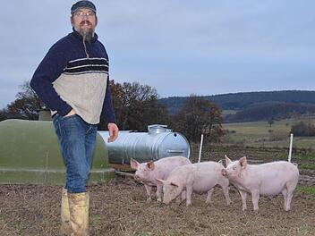 Burkard Mahlmeister aus Stangenroth vermarktet seit 1993 sein erzeugtes Fleisch und die selbst produzierten Wurstwaren selbst. Hier steht er in einem Freilandgehege seines Hofs, in dem diese drei Schweine zu Hause sind.  Foto: Kathrin Kupka-Hahn