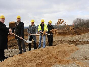 Der Discounter investiert in der Büg bei Eggolsheim einen zweistelligen Millionenbetrag in ein neues Lager. Regierungspräsident Wilhelm Wenning, Bürgermeister Claus Schwarzmann, Geschäftsführerin Tina Pfeiffer, Bauleiter Volker Gradl und Landrat Reinhardt Glauber (von links) griffen zur Schaufel. Foto: Josef Hofbauer
