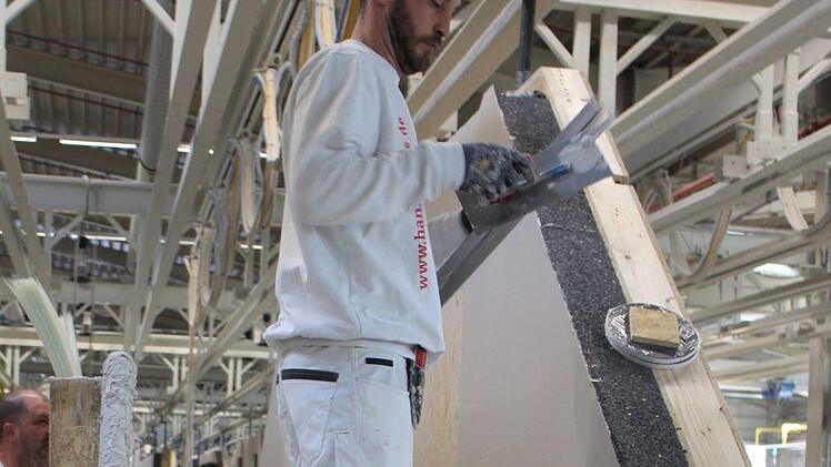 Ein Mann verputzt die Hauswand noch im Werk in Oberleichtersbach. Foto: Julia Raab