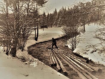 Dieses aussagestarke Bild, etwa um 1920 am Doberbach unterhalb von Tschirn bei der beginnenden Schneeschmelze im März aufgenommen, dokumentiert eindrucksvoll die einst problematischen Fahrten der Floßknechte auf ihren Kuppeln. Bei diesen akrobatischen Einsätzen waren die Männer gnadenlos Kälte und Nässe ausgesetzt.  Repros: Gerd Fleischmann