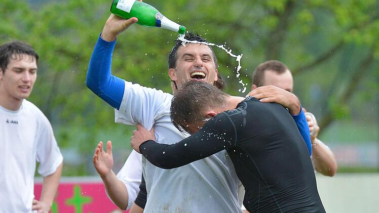 So sehen Sieger aus: Hemhofens Spielertrainer Costa Büle lässt nach dem Schlusspfiff den Emotionen freien Lauf und den Aufsteigersekt fließen. Fotos: Picturedreams