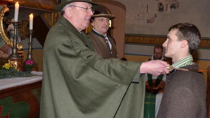 Er ist derzeit der jüngste unter den Jungjägern der Kreisgruppe Kronach. Der 19-jährige Christian Ebert (rechts) erhält den Jägerschlag durch Ehrenmitglied Alexander Lücker (links). Mit im Bild, der Kreisvorsitzende Bernhard Schmitt (2.v.l.), im Hintergrund sitzend, Regionaldekan Thomas Teuchgräber, selbst auch passionierter Jäger.