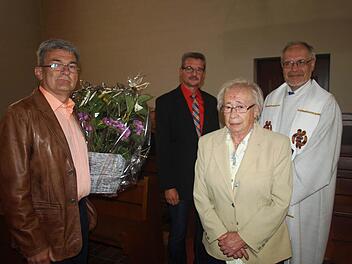 Sich um die Grotte zu kümmern, ist seit 50 Jahren für Regina Schmitt ein Herzensanliegen. Bei einer Marienandacht in der Kirche dankten ihr dafür Pfarrer Edwin Ziegler (rechts), Kirchenpfleger Klaus Kiesel (links) und Roland Seufert für den Pfarrgemeinderat.  Foto: Stefan Geiger