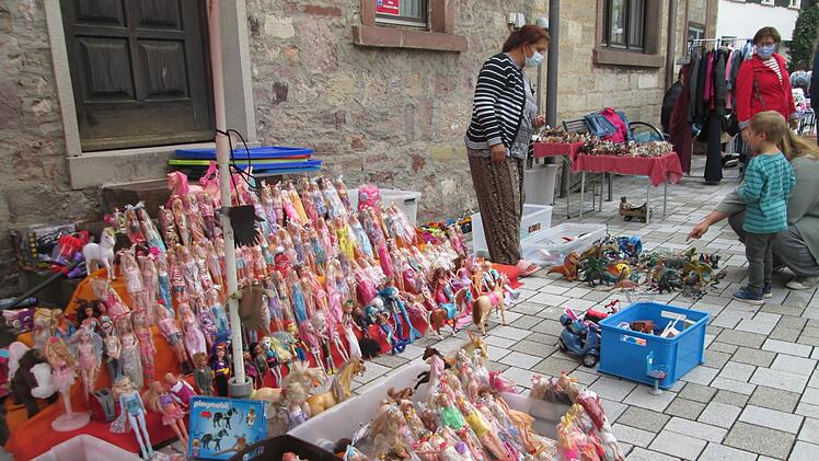 Barbie-Puppen und Plastik-Dinosaurier ziehen die Aufmerksamkeit der Kleinsten auf sich. Foto: Winfried Ehling