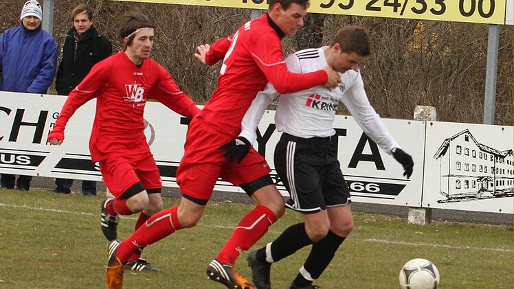 Der Sander Fabian Benkert (rechts) wird von dem Aubstadter Kapitän Daniel Werner (Zweiter von rechts) attackiert.