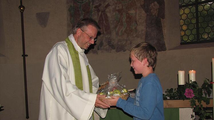 Ein bodenständiges Geschenk, einen Präsentkorb mit etlichen leiblichen Genüssen hatte eines der jüngeren Gemeindeglieder, Constantin Raabs, für Pfarrer Hans-Jürgen Pöschl mitgebracht. Foto: Martin Koch