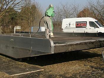 Mit zermahlener Hochofenschlacke wird derzeit die Pettstadter Fähre abgestrahlt. Nach Ausbesserungsarbeiten und neuen Schutzanstrichen wird sie wieder in die Regnitz gehoben, um ab Ende März ihren Dienst aufzunehmen.  Foto: Werner Baier