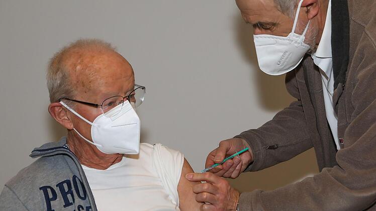 Dr. Joachim Mörsdorf (rechts), ärztlicher Leiter des Forchheimer Impfzentrums, verabreicht einem Landkreisbürger eine Spritze mit dem Impfstoff gegen das Coronavirus. Foto: Barbara Herbst