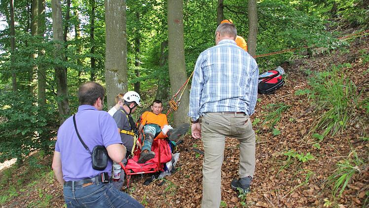Der verletzte Waldarbeiter wird auf die Gebirgstrage gelegt. Das Bild zeigt (von links): Klaus Dressel, Nadja Müller, Ralf Schmidt, Marco Fischer und Herbert Eisentraudt.   Foto: Friedwald Schedel