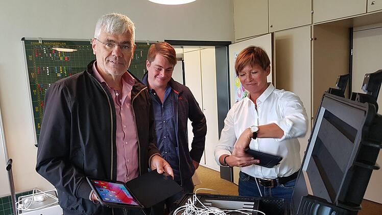Bernhard Storath (von links), Tobias Walter und Ursula Schüßler schauen sich die I-Pads und den Transportkoffer an.