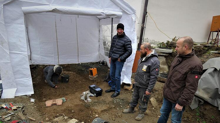 Bei den Bauarbeiten für das neue Bürgerzentrum  ist man auf Knochenreste gestoßen. Unser Bild entstand an einem fast vollständig erhaltenen Kindergrab. Bürgermeister Jochen Trier, Archäologe Robert Karl und Projektleiter Norbert Specht (von rechts) verfolgen die Freilegung der Gebeine.Werner Reißaus