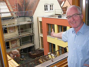 Johannes Simon, Leiter von Pfarrbriefservice.de und Vorsitzender des Caritas-Kreisverbandes, bei einem Blick aus seinem neuen Büro. Der Westflügel ist fertig, doch sonst wird noch fest gebaut. Foto: Ralf Naumann
