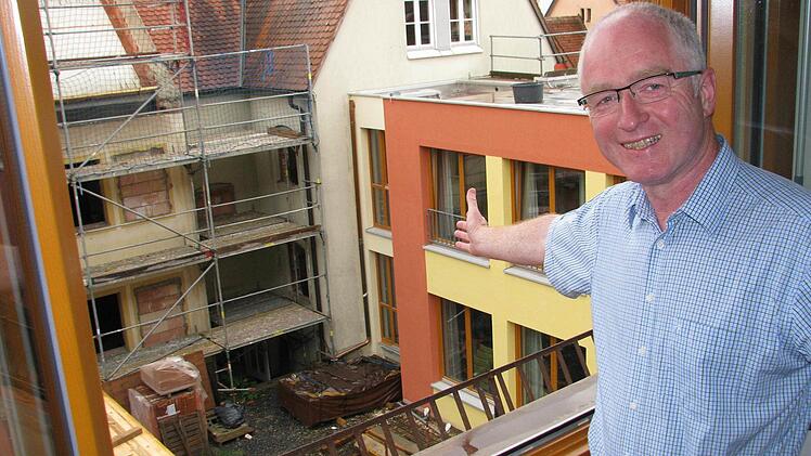 Johannes Simon, Leiter von Pfarrbriefservice.de und Vorsitzender des Caritas-Kreisverbandes, bei einem Blick aus seinem neuen Büro. Der Westflügel ist fertig, doch sonst wird noch fest gebaut. Foto: Ralf Naumann
