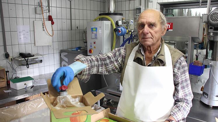 Hermann Schneider zeigt die Technik der Fünf-Liter-Beutel, die in Kartons sicher verstaut werden.