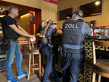 Polizisten in einer Gaststätte bei einer Arbeitnehmerkontrolle im Einsatz: Ist Schwarzarbeit die Ursache dafür, dass viele Bürgergeldempfänger unansprechbar sind?