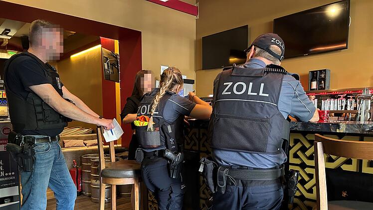 Polizisten in einer Gaststätte bei einer Arbeitnehmerkontrolle im Einsatz: Ist Schwarzarbeit die Ursache dafür, dass viele Bürgergeldempfänger unansprechbar sind?