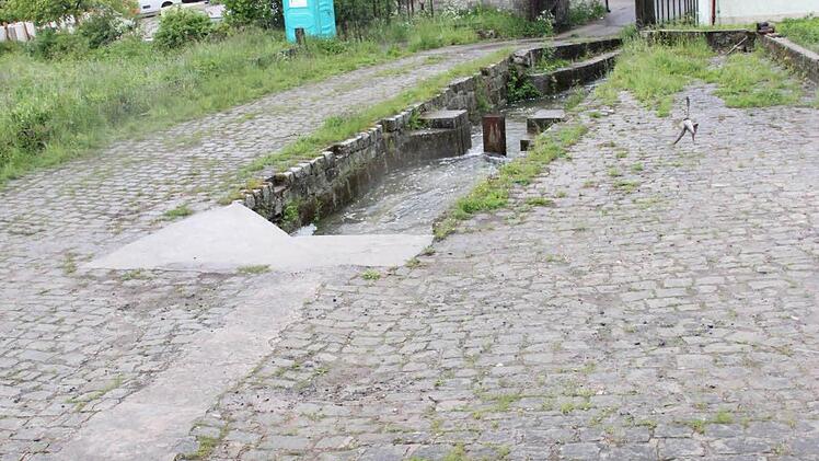 Blick vom Damm aus in Richtung Ortschaft - durch den Kanal fließt das Wasser aus dem Dorfweiher in die Aurach ab.