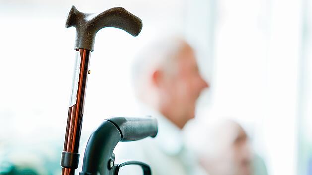 Ein Gehstock und Rollator im Vordergrund, unscharfe &auml;ltere Personen im Hintergrund. Thema: Dank an pflegende Angeh&ouml;rige, obwohl der geplante Dankesch&ouml;n-Tag entf&auml;llt.
