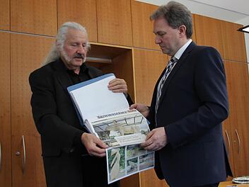 "HolzArt"-Initiator Ingo Cesaro übergibt den Pressespiegel an Landrat Klaus Löffler.  Foto: Ronald Heck
