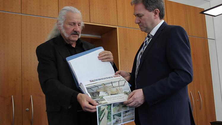 "HolzArt"-Initiator Ingo Cesaro übergibt den Pressespiegel an Landrat Klaus Löffler.  Foto: Ronald Heck