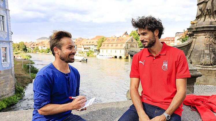 Sportreporter Daniel Ruppert im Gespräch mit Michele Vitali auf der Unteren Brücke in Bamberg.
