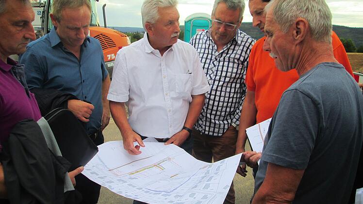 Bürgermeister Peter Hart (M.) und der Gemeinderat informierten sich vor Ort anhand der Pläne von Bautechniker Uwe Mützel (2. v. r.).