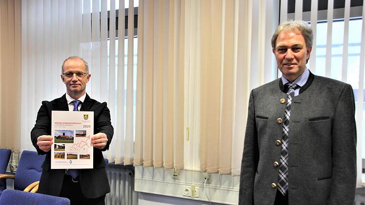 Manfred Müller, Mitglied im Gutachterausschuss für Grundstückwerte, übergibt dem Landrat ein erstes Exemplar des Immobilienmarktberichts. Foto: Veronika Schadeck