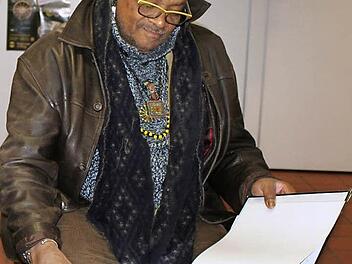 Famoudou Don Moye betrachtet im Staffelsteiner Museum die Fotos von Mitgliedern der 3511. Quartermaster Truck Company in Staffelstein von 1946, die vom John II Withers, USA, stammen. Foto: Adelheid Waschka