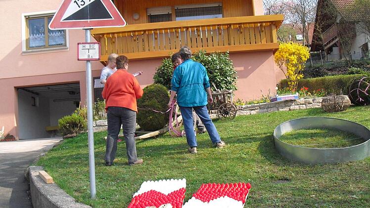 Zum Schluss wird der Osterbrunnen geschmückt. Foto: Helmut Klösel