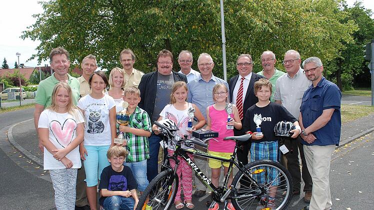 Die glücklichen Sieger des Ehrenwimpelturniers, hinter dem Fahrrad. In der Mitte die Erstplatzierte und neue Fahrradbesitzerin Ruth Küfner, 2. Raffaela Strömisch, links daneben, 3. Leon Krügel, rechts. Neben den Gewinnern des Wanderpokals der Schule Marktschorgast, vorne links, gratulierten Ehrengäste und Verantwortliche.